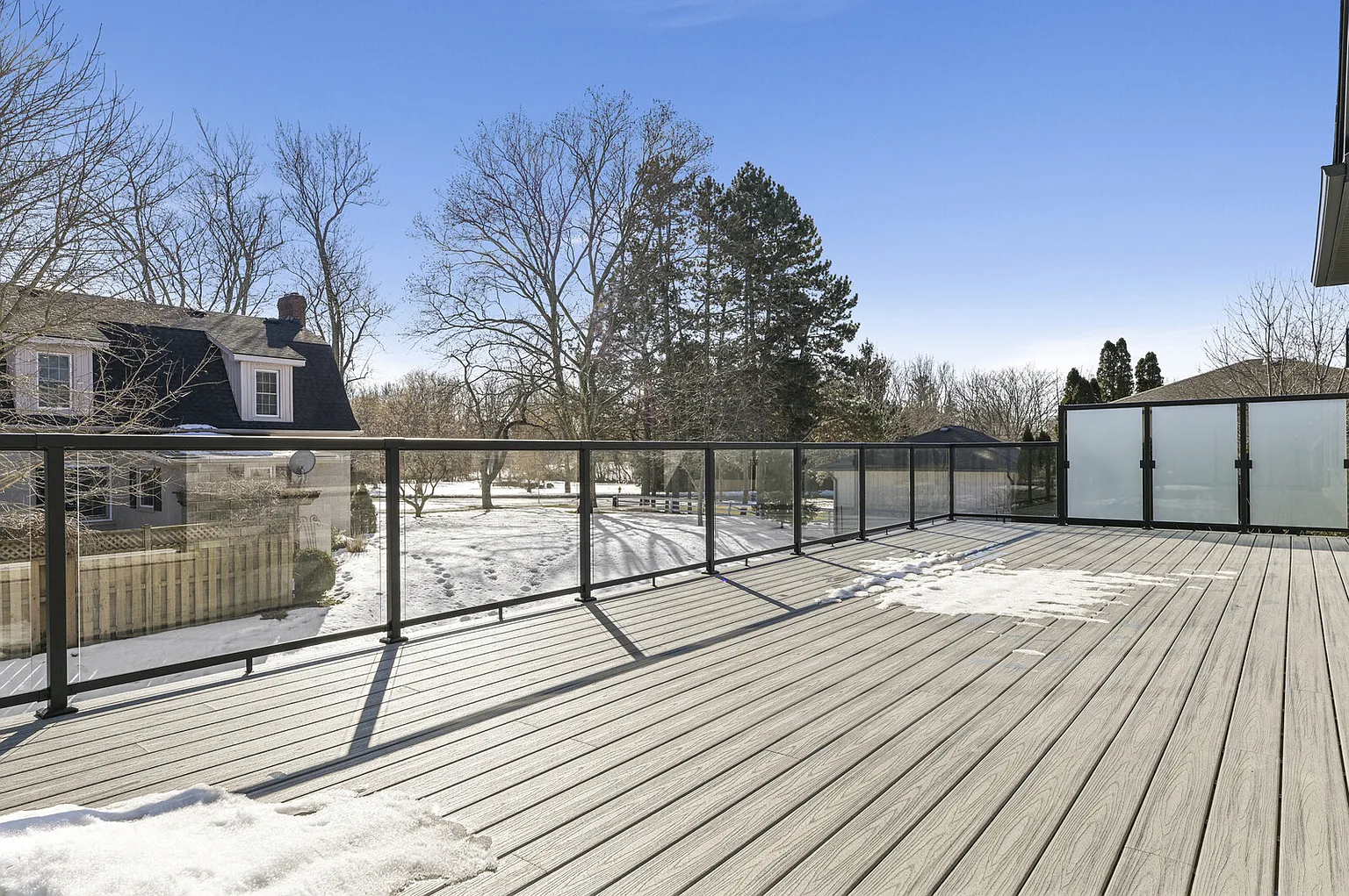 Composite deck with glass railings and privacy screen
